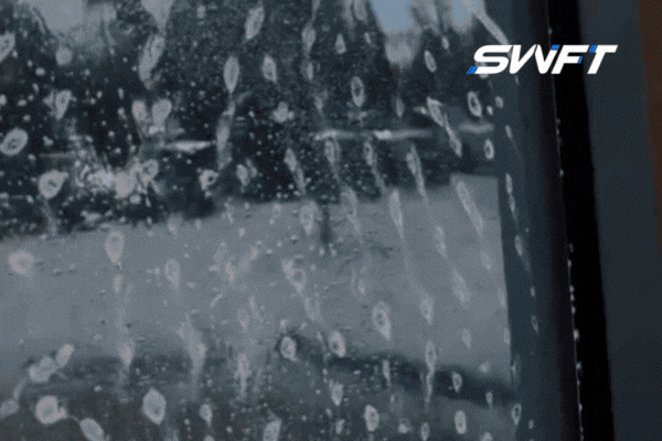 A technician from Southwest Florida Tinting applies security window film to a commercial glass window in Fort Myers, with water and adhesive visible during installation. This process highlights the professional application of Security Window Film to ensure optimal protection and clarity for business properties.